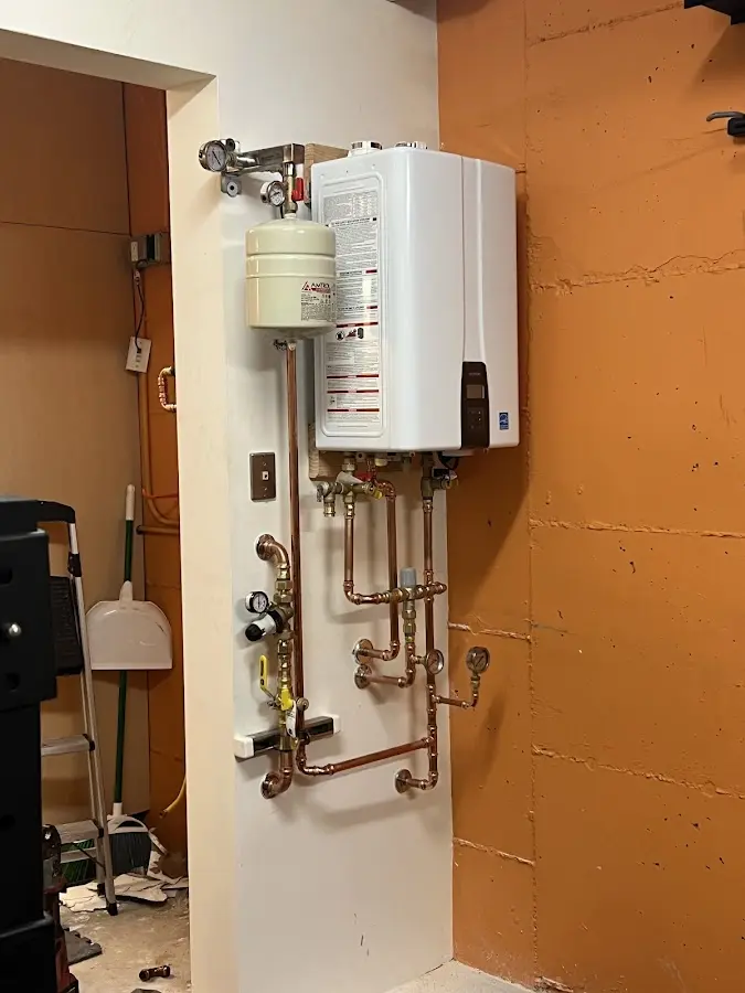 Plumbing technician inspecting water heater connections in Culpeper